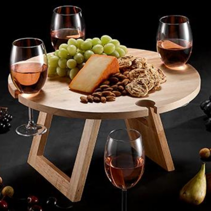 Full picnic table with wine glasses on black background